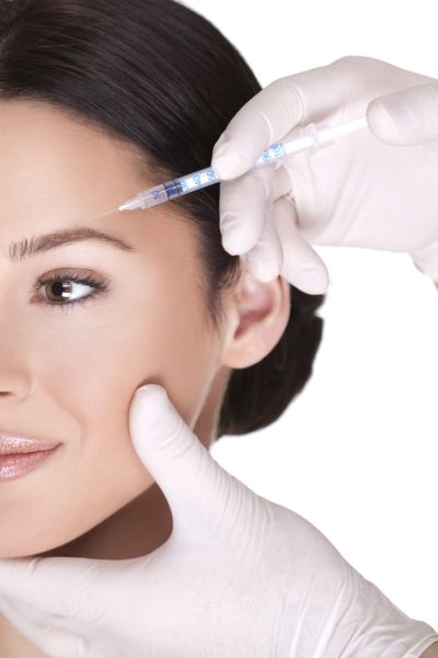 Close-up of cosmetic injection of botox in the wrinkles on the forehead